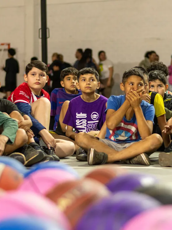 Chicos y adolescentes sentados en las gradas durante un entrenamiento.