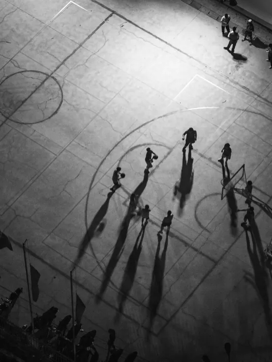 Vista cenital de una cancha con las sombras largas de los jugadores.